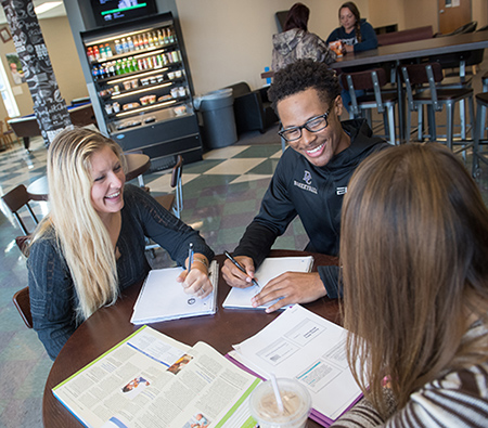 Students with papers at 41 North coffee shop on campus