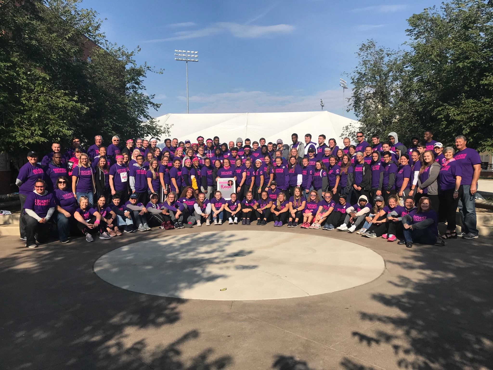 Large group of students and staff at Race for the Cure in purple DC shirts