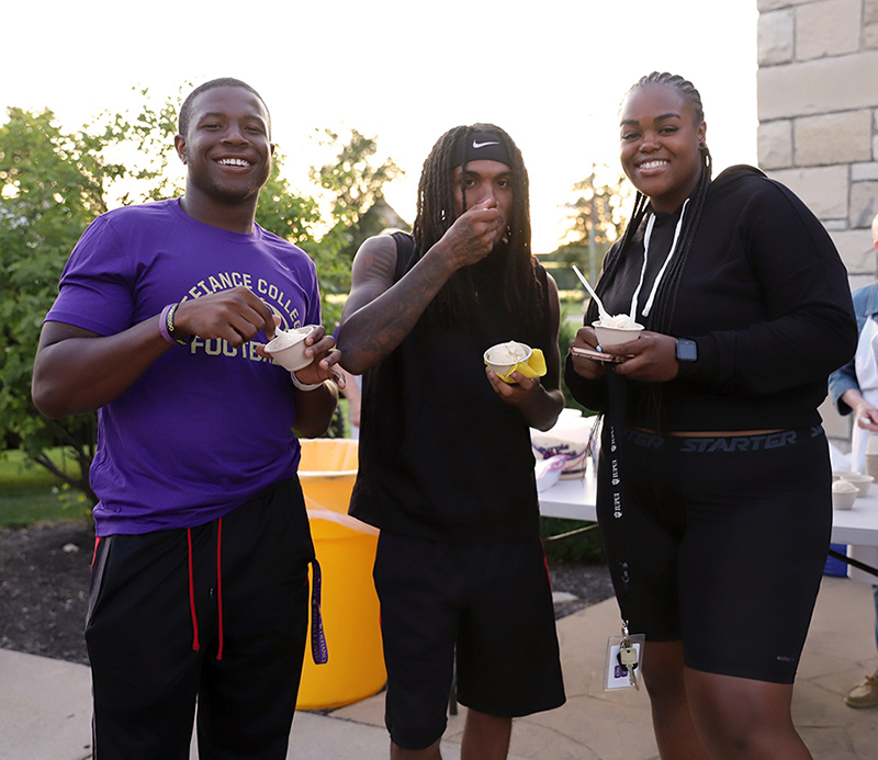 Three students eating ice cream and smiling at the camera