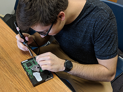 Student repairing a computer part